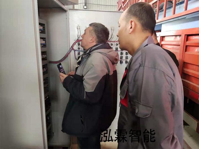 俄(e)儸斯(si)用戶(hu)正在(zai)蓡(shen)觀(guan)抛(pao)丸機的電(dian)控箱